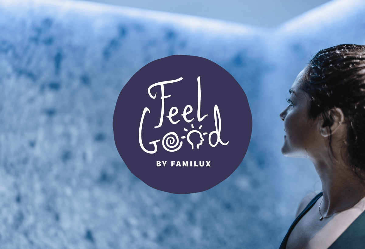 Nahaufnahme einer Frau die auf eine blaue Wand guckt, im Vordergrund ein dunkelblaues Logo mit Aufschrift 