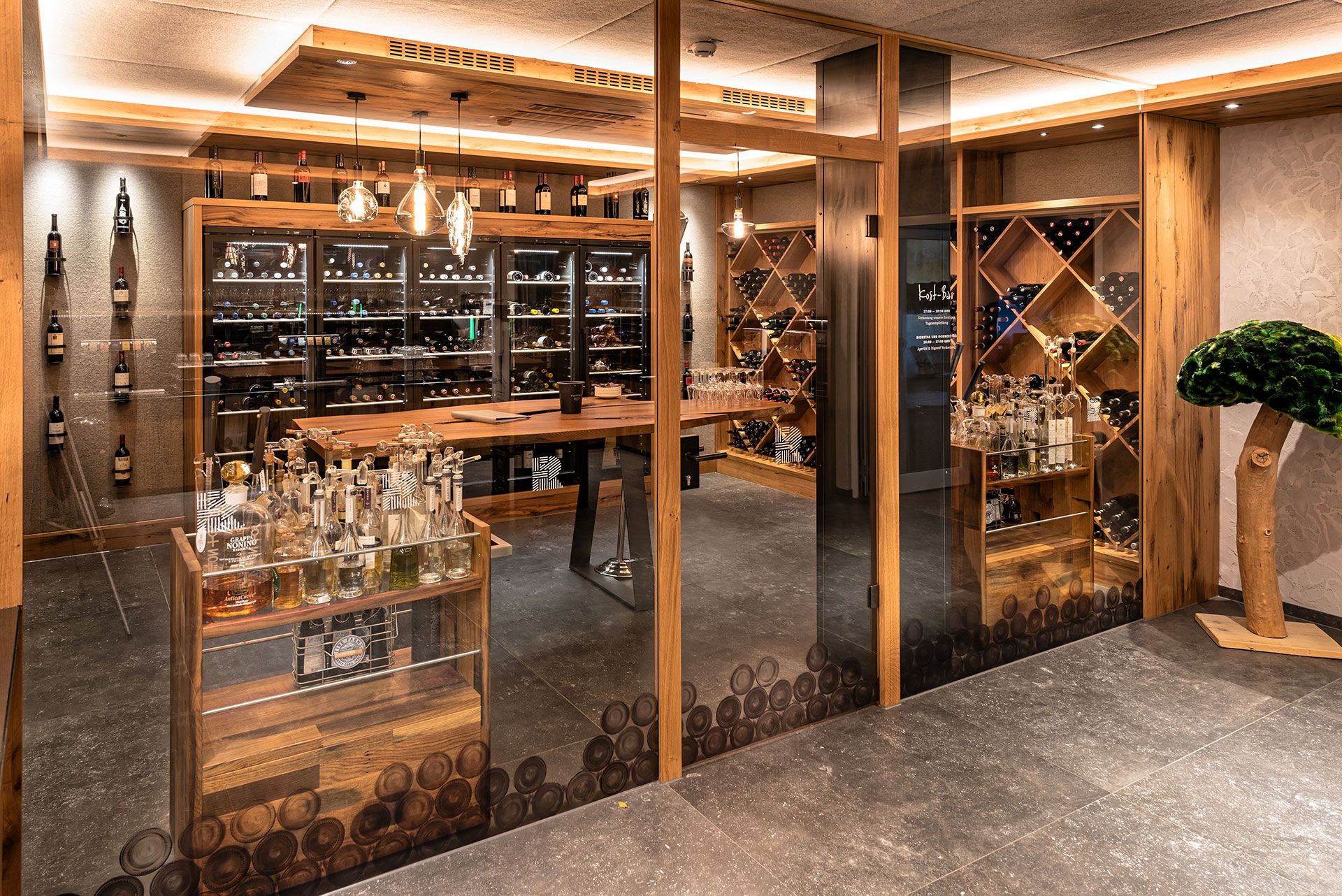 Exterior view of the Vinothek in wooden tones with many wine bottles lying on the shelves.